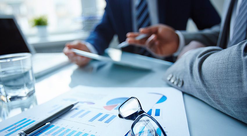 Profesionales revisando gráficos e informes en una reunión de trabajo