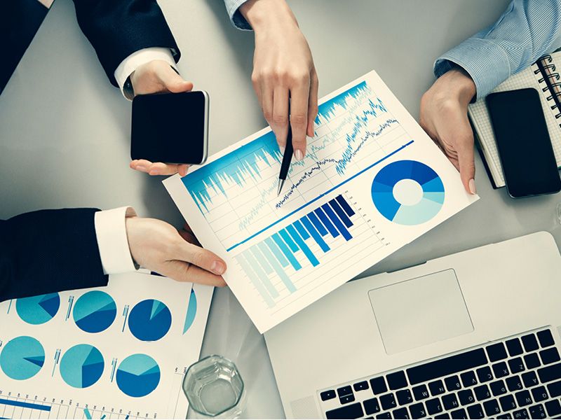 Personas revisando gráficos impresos de resultados de una encuesta